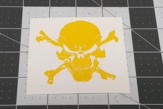 a yellow skull and crossbones sticker is on the floor next to a black and white tile