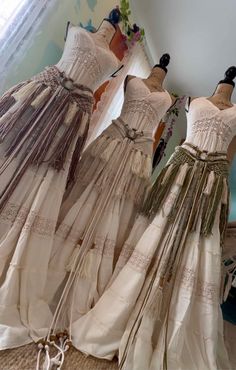 three dresses on mannequins in front of a mirror