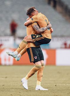 two soccer players are hugging each other on the field