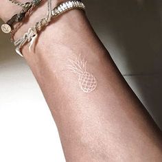 a woman's arm with a pineapple tattoo on it