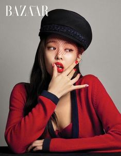 a woman with red nails and a black hat on her head is posing for the cover of bazaar magazine