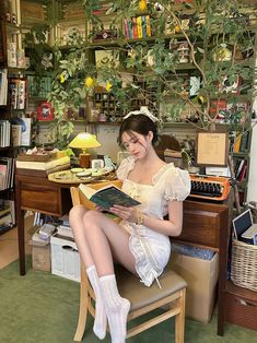 a woman sitting at a desk with a book in her lap and wearing white socks