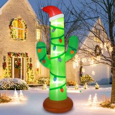 an inflatable christmas cactus with santa's hat on it stands in front of a house