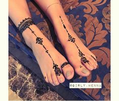 two feet with henna tattoos on them, one is black and the other is white