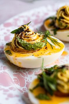 three deviled eggs topped with an assortment of toppings