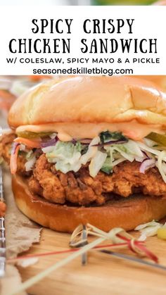 a chicken sandwich with coleslaw, spicy mayo and a pickle on it