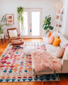 a living room filled with furniture and lots of pillows on top of a wooden floor