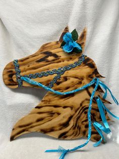 a wooden horse head with blue ribbon on it