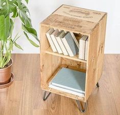 a wooden book shelf with books on it and a potted plant next to it