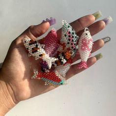 a hand holding several small beaded objects