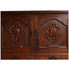 an ornate wooden cabinet with carvings on the front and side panels, in dark wood