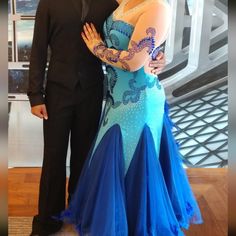 a man standing next to a woman in a blue dress