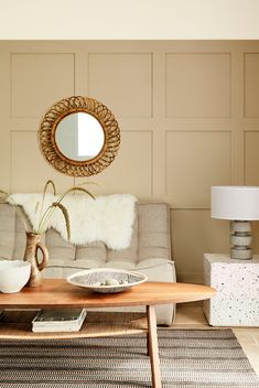 a living room filled with furniture and a mirror on the wall over a coffee table