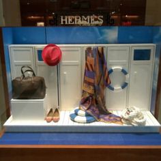 a display case with hats, scarves and purses