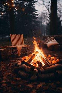 a campfire with logs and chairs around it