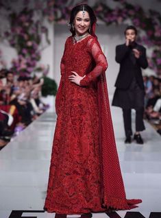 a woman in a red dress on the runway