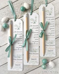 three green and white tags with wooden sticks attached to them on a wood table next to eggs