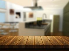 an empty wooden table top in front of a blurry kitchen and dining room background