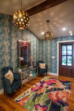 a living room filled with furniture and a rug on top of a hard wood floor