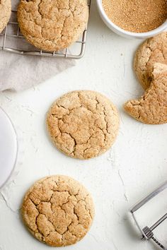 three cookies on a cooling rack next to a cup of coffee