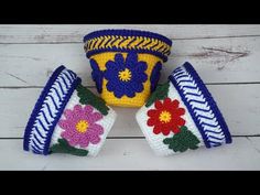 three crocheted flower pots sitting next to each other on a white wooden surface