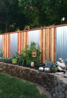 an outdoor garden area with various plants and potted plants in front of a fence