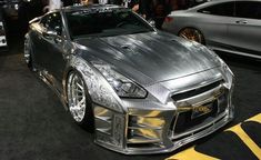 a silver sports car on display at an auto show