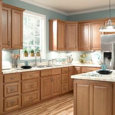 a kitchen filled with lots of wooden cabinets and counter top space next to a window