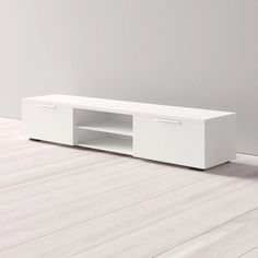 a white entertainment center with two drawers on the bottom and one door open to reveal an empty room