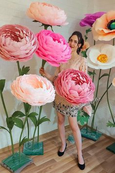 a woman standing in front of large flowers