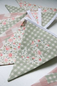 three pieces of fabric are laid out on the table to be used as pennants