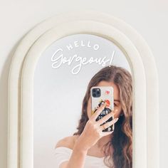 a woman taking a selfie in front of a mirror with the words hello gorgeous on it