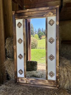 a mirror sitting on top of hay bales in front of a barn with hay bales