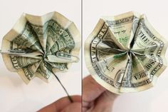 the dollar bill origami is being held by someone's hand with scissors