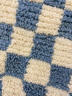 a blue and white checkered blanket on the floor