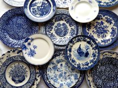 many blue and white plates stacked on top of each other