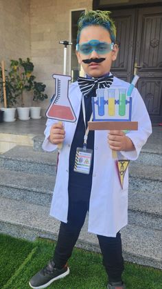 a young boy dressed as a scientist holding flasks and test tubes in his hands