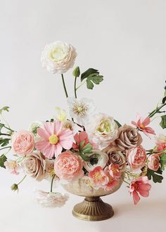 a vase filled with lots of flowers on top of a table