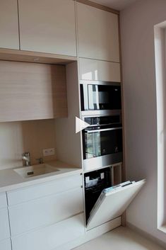 a kitchen with two ovens in the middle of it and an open window above them