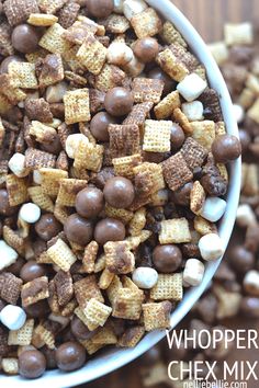 a bowl filled with chocolate and marshmallows on top of a wooden table