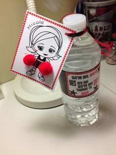 a bottle of water with a red pom - pom attached to it