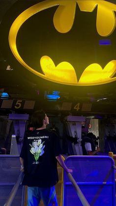 a man standing in front of a batman sign