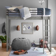 a loft bed with ladders is in the middle of a room that has a blue rug on the floor