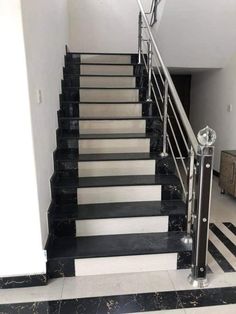 black and white stairs leading up to the second floor in an apartment with marble floors