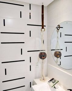 a white sink sitting under a mirror in a bathroom next to a wall mounted faucet