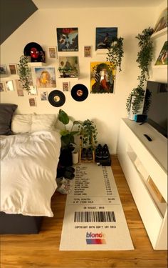 a bed room with a neatly made bed and lots of pictures on the wall