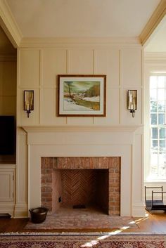 a living room with a fire place and a painting hanging on the wall above it