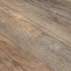 a close up view of the wood flooring in a bathroom with tile on the floor