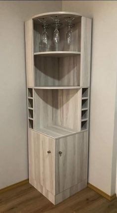 a corner cabinet with wine glasses on top