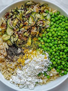 a white bowl filled with rice, peas and other vegetables next to broccoli